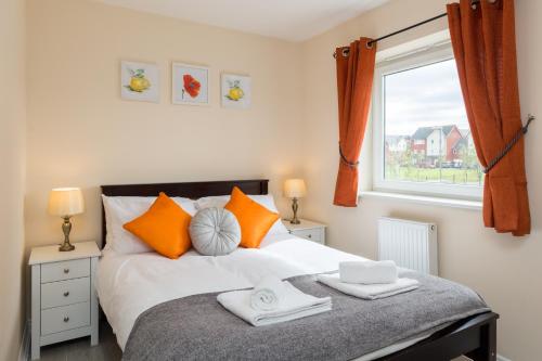 a bedroom with a bed with orange pillows and a window at Wolverhampton City Stay in Wolverhampton