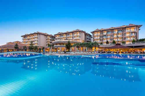 a large swimming pool with buildings in the background at Adalya Art Side - Ultra All Inclusive in Side