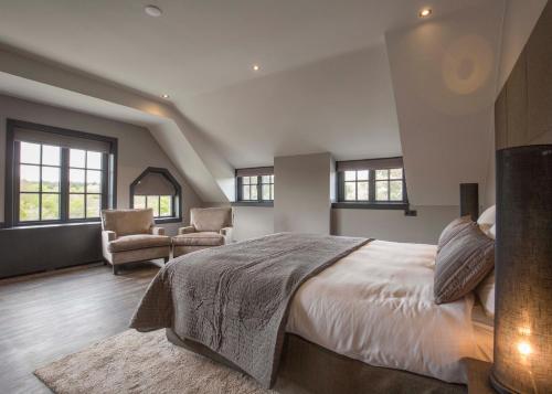 a bedroom with a large bed and two chairs at Fletcher Boutique Hotel Duinoord in Wassenaar