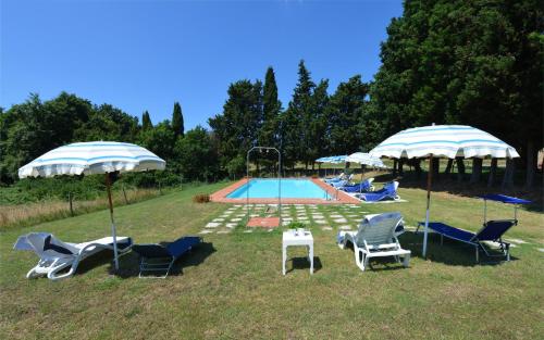 a group of chairs and umbrellas next to a pool at Agriturismo Tenuta Vallelunga in Guasticce