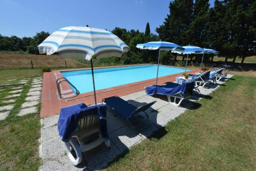 a group of chairs and umbrellas next to a swimming pool at Agriturismo Tenuta Vallelunga in Guasticce