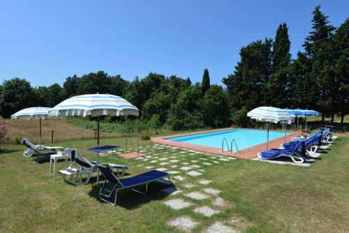 a pool with a bunch of chairs and umbrellas at Agriturismo Tenuta Vallelunga in Guasticce