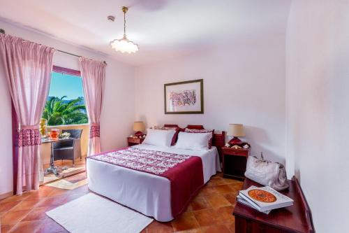 a bedroom with a bed and a window at Residence Sos Alinos in Cala Liberotto