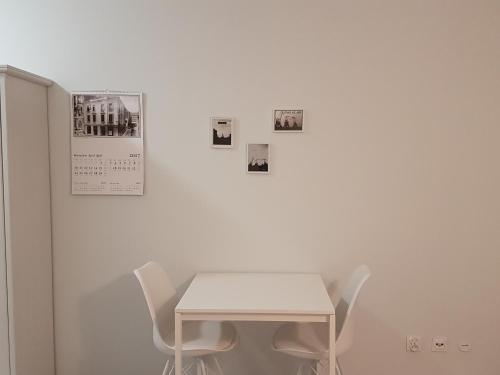 a white table and chairs against a white wall at Cukrownia in Szczecin