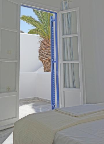a bedroom with a bed and an open door at Nicos Studios & Apartments in Logaras