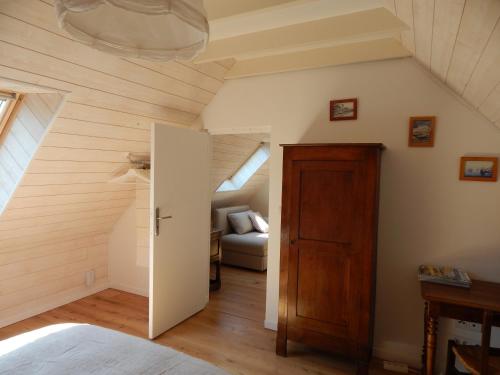 a attic room with a door and a couch at Balade Océane in Loctudy
