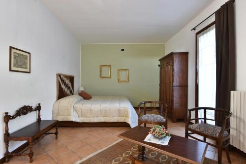 1 Schlafzimmer mit einem Bett, 2 Stühlen und einem Tisch in der Unterkunft Il Terrazzo B&B in Romagnano Sesia