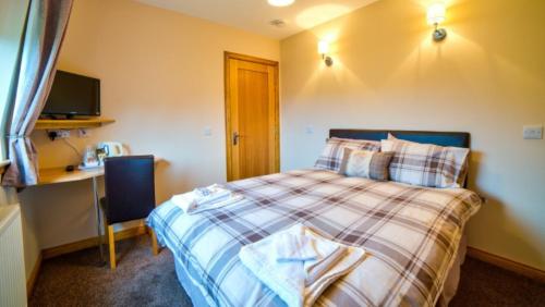 
a bedroom with a bed and a television at Kilcumin Guest House in Inverness
