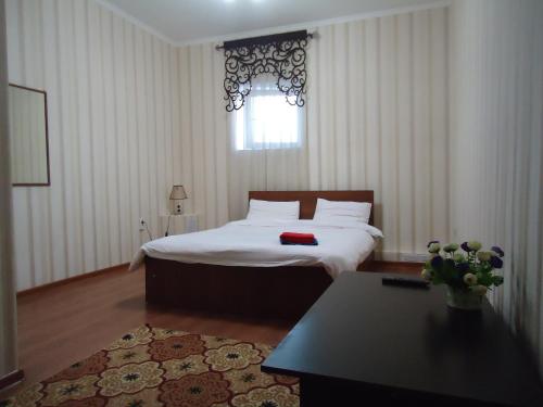 1 dormitorio con cama y ventana en Tumar en Bishkek