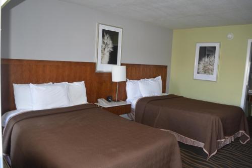 una habitación de hotel con 2 camas y una lámpara en Jameson Inn Winder, en Winder