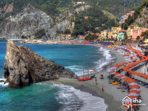 a beach with a bunch of umbrellas and the ocean at Comodità città-mare Cinque Terre in La Spezia