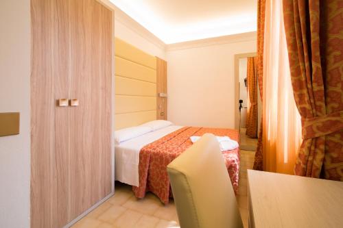 a hotel room with a bed and a door at Hotel Carancini in Salsomaggiore Terme