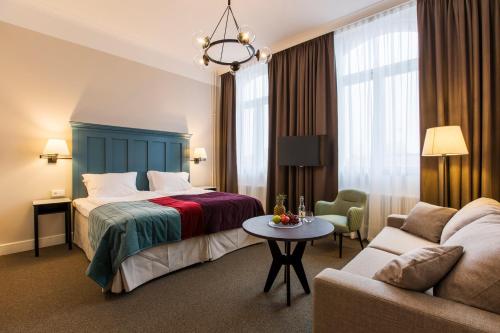 um quarto de hotel com uma cama e um sofá em Elite Hotel Mimer em Umeå