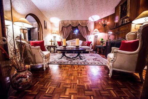 a living room with a couch and a table and chairs at Hotel La Mansion del Sol in Guadalajara