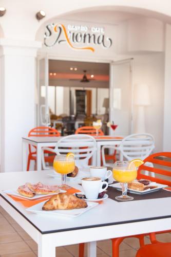 een witte tafel met eten en drinken erop bij Typic Oasis Sa Tanca in Cala Llonga