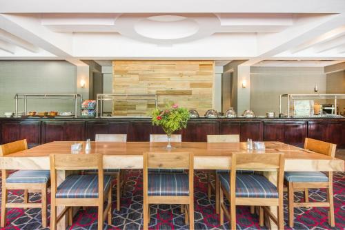 a dining room with a large wooden table and chairs at Wyndham Garden Inn Pittsburgh Airport in Robinson Township