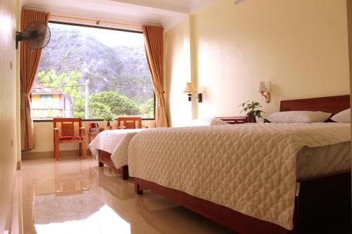 a bedroom with a bed and a large window at Sierra Homestay in Ninh Binh