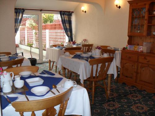 a dining room with tables with blue and white dishes at The Florida Guest House in Paignton