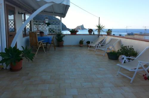 patio z krzesłami i stołem oraz oceanem w obiekcie B&B LA TERRAZZA w mieście Marettimo