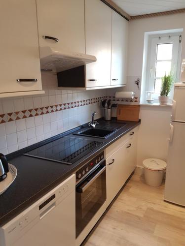 a kitchen with a sink and a stove top oven at Strandgut - das appartement in Schönhagen