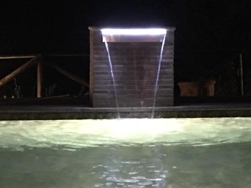 a water fountain at night with a light at Villa valtopina in Valtopina