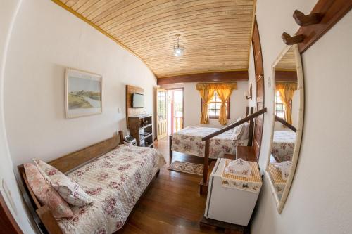 a room with two beds and a staircase with a mirror at Pouso Lar Doce Lar in Tiradentes
