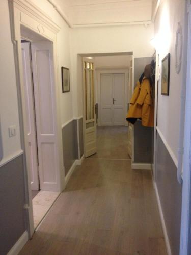 ヴェローナにあるMax Apartmentの白い壁と木製の床の廊下