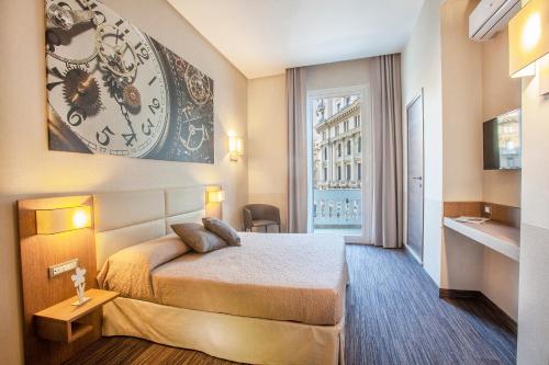 ナポリにあるB&B Dimora San Feliceのベッドと壁に時計があるホテルの部屋