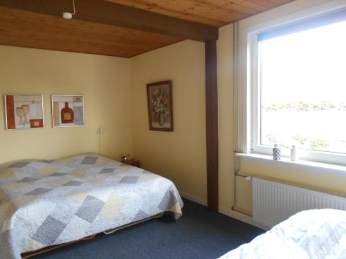 a bedroom with a bed and a large window at Marskferie Tønder in Tønder