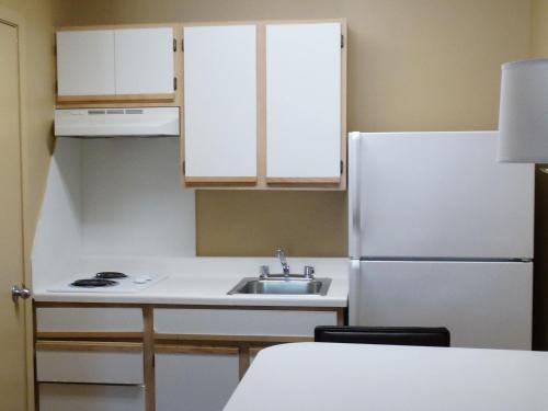 a white refrigerator freezer sitting in a kitchen at Extended Stay America Suites - Boca Raton - Commerce in Boca Raton