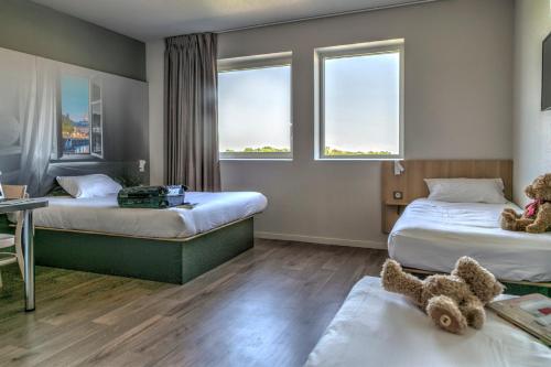 מיטה או מיטות בחדר ב-B&B HOTEL Bordeaux Est