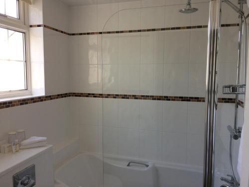 a white bathroom with a shower and a tub at Sid Valley Country House Hotel in Sidmouth