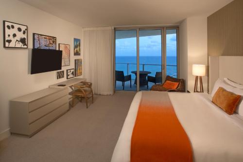 Una habitación de hotel con una cama grande y un televisor. en Lyfe Resort & Residences, en Hollywood