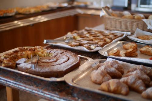 a buffet filled with different types of pastries and bread at Hotel Colorado Cesenatico in Cesenatico