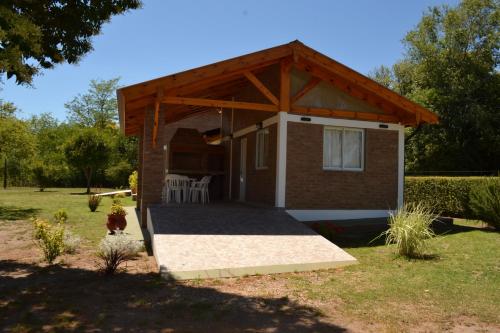 a small cabin with awning in a yard at Der Wald cabañas in Los Reartes