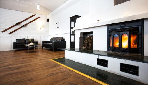 a fireplace in a living room with two chairs and a couch at Thon Partner Hotel Narvik in Narvik