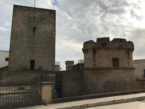 an old castle with a fence in front of it at Li Caseddi ti lu Cesarinu in Avetrana