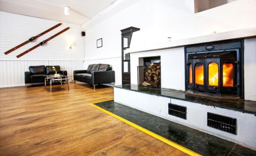 a living room with a fireplace with two chairs at Thon Partner Hotel Narvik in Narvik