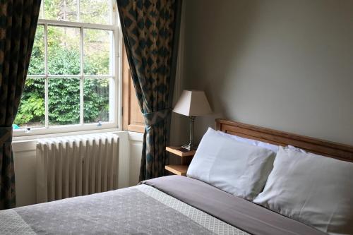 a bedroom with a bed and a window at Ashtree House Hotel, Glasgow Airport & Paisley in Paisley
