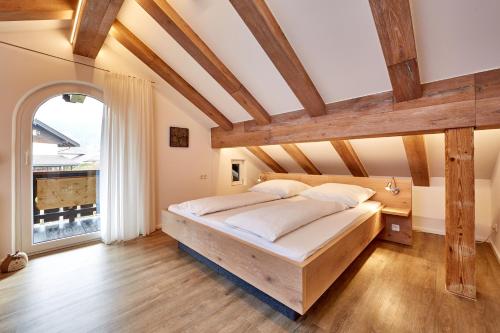 Schlafzimmer mit einem großen Bett mit Holzbalken in der Unterkunft Ferienwohnung Wittmann in Garmisch-Partenkirchen