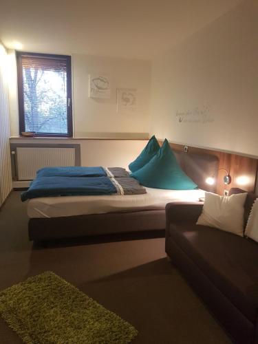 ein Schlafzimmer mit einem Bett und einem Sofa in der Unterkunft TERAMO Restaurant Hotel Mühlenstein in Grünhagen
