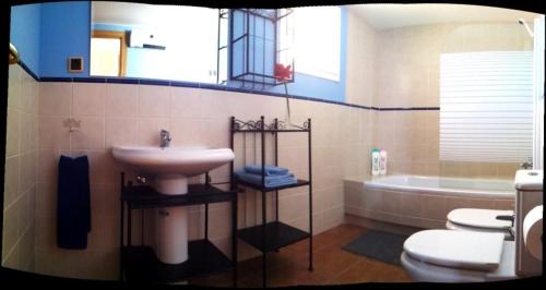 a bathroom with a sink and a toilet and a tub at Casa el Aljibe in Lanaja