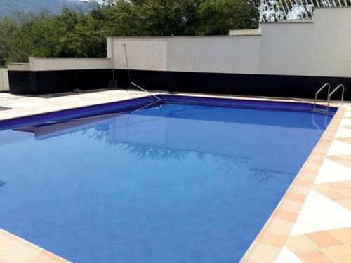 a swimming pool with blue water in front of a building at Apartamento Santamore II in San Gil