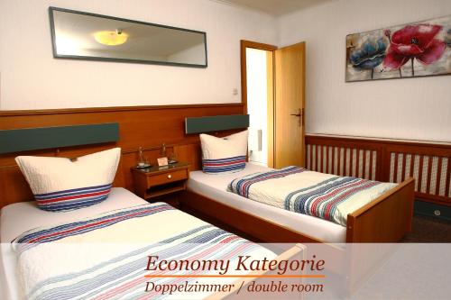 a hotel room with two beds and a mirror at Hotel-Restaurant Wanders in Elten