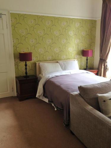 a bedroom with a bed and a couch at Ashtree House Hotel, Glasgow Airport & Paisley in Paisley