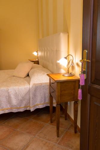 a bedroom with a bed and a table with a lamp at B&B Le Foglie D'Argento in Caltabellotta