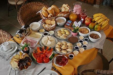 a table with a bunch of food on it at Pousada Aconchego in Monte Verde