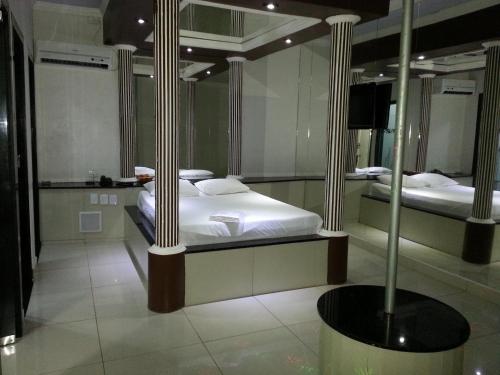 2 letti in una camera con due pali di Shopping Motel Santa Maria do Pará a São Jorge
