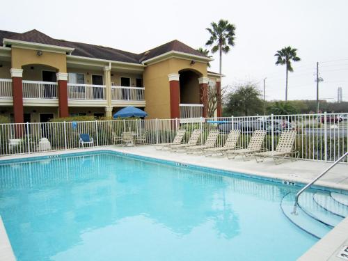 a swimming pool in front of a house with chairs at Extended Stay America Suites - Clearwater - Carillon Park in Clearwater