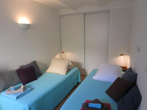 Cette chambre comprend deux lits et un canapé. dans l'établissement Appartement avec jardin, à Cannes